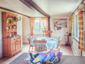 una sala da pranzo con un tavolo e sedie in una stanza di The Mansion Cottage a Tetford