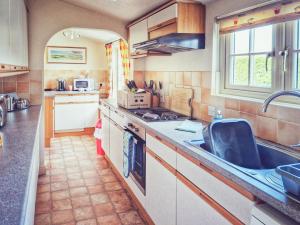 una cucina con un lavello e un piano di lavoro di The Mansion Cottage a Tetford Altre 8 foto