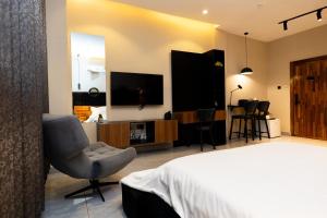 a bedroom with a bed and a chair and a television at The Seed Plaza in Kumasi +21 photos