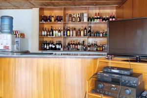 un bar con muchas botellas de alcohol en Palm Grove Saud Holiday Complex Hotel, en Burayoc