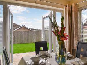 een tafel met daarop een vaas met bloemen bij Oceans 44 in Sewerby