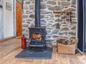 einem Holzofen vor einer Steinmauer in der Unterkunft Little Penquite in Landrake