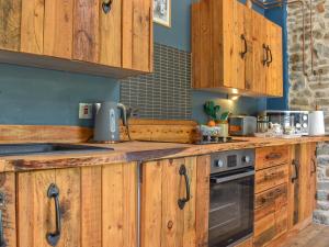 eine Küche mit Holzschränken und einem Herd in der Unterkunft Little Penquite in Landrake