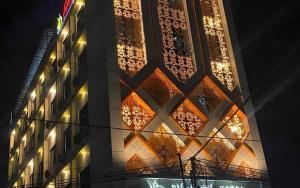 Un edificio con luces en el costado. en Hotel Dynasty, en Sibengkok