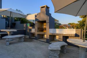 un patio con dos mesas y dos sombrillas en Montrose BnB, en Margate