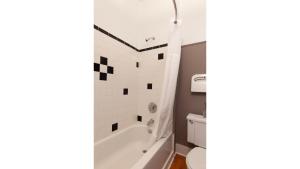 een badkamer met een wit bad en een toilet bij Zane Grey - Historic Hotel in Cimarron