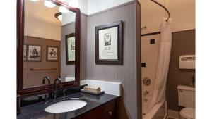 een badkamer met een wastafel en een spiegel bij Zane Grey - Historic Hotel in Cimarron