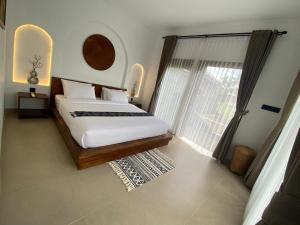 テテバトゥにあるSagunalam Tetebatuのベッドと大きな窓のある寝室 +3枚の写真