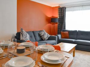 ein Wohnzimmer mit einem Tisch und einem blauen Sofa in der Unterkunft Ransdale Cottage in Bridlington