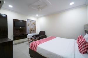 ein Hotelzimmer mit Bett und Fernseher in der Unterkunft Open Hotel by Olive - Hotel Siddartha Elite in Vijayawada