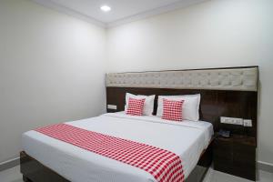 ein Schlafzimmer mit einem großen Bett mit einer roten und weißen Decke in der Unterkunft Open Hotel by Olive - Hotel Siddartha Elite in Vijayawada