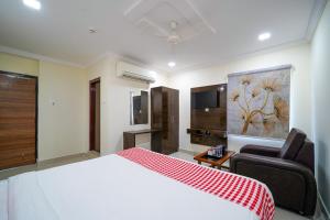 ein Schlafzimmer mit einem Bett, einer Couch und einem Fernseher in der Unterkunft Open Hotel by Olive - Hotel Siddartha Elite in Vijayawada + 41 Fotos