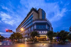 成都市にあるJames Joyce Coffetel Chengdu Jichang Road Shenxianshuの信号のある街路沿いの建物