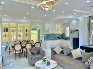 a kitchen and living room with a couch and a table at Villa Giọt Nắng Phan Thiết in Phan Thiet