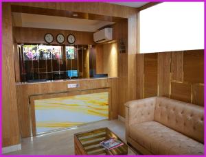 a living room with a couch and a table and clocks at PRIME LOCATION NEAR SEA BEACH HOTEL NILADREE WAVES! Puri - Near Jagannath Temple and Golden Beach- Swargadwar Beach - Bengali Market - A Top Rated Hotel IN PURI in Puri