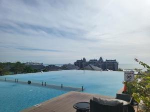 a large swimming pool with buildings in the background at Villa Giọt Nắng Phan Thiết in Phan Thiet