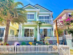 a white picket fence in front of a house at Villa Giọt Nắng Phan Thiết in Phan Thiet