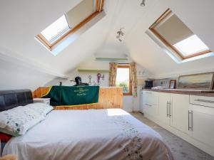 ein Schlafzimmer mit einem Bett und einigen Oberlichtern in der Unterkunft The Old Tack Room - Uk49233 in Tilshead