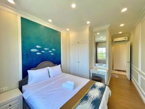 a bedroom with a bed with a painting on the wall at Villa Giọt Nắng Phan Thiết in Phan Thiet +38 photos