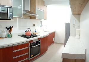 eine Küche mit einem Teekessel auf einem Herd in der Unterkunft Apartamento familiar amplio y cómodo en Pueblo Libre in Lima