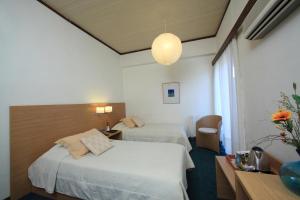 A bed or beds in a room at Dioscouri Hotel