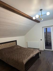 a bedroom with a bed and a large window at Корчин Гарден Шале in Korchin