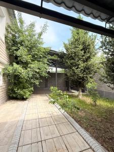 einen Gang vor einem Gebäude mit Bäumen in der Unterkunft Villa chimbulak in Almaty