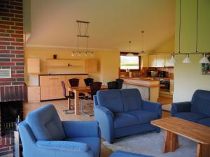 a living room with two blue chairs and a table at Ferienlandhaus Tossens in Butjadingen