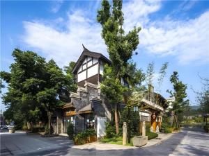 a house with a tree in front of it at James Joyce Coffetel Chengdu Longquan Dongfang Huada Plaza in Chengdu