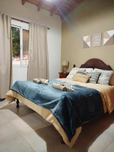 Un dormitorio con una cama grande con una manta azul. en Open Beach, en Aguas Verdes