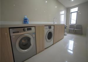 a laundry room with a washer and dryer at Echarm Hotel Yiyang Wanda Plaza in Heshanqu