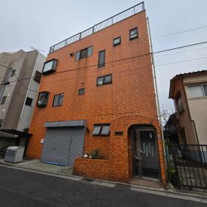 a red brick building with a garage on a street at Near Koiwa st 202 private Room in Tokyo