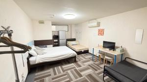 um pequeno quarto com uma cama e uma secretária em 難波南52 em Osaka