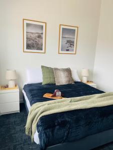 una camera da letto con un letto con una coperta blu e due lampade di The Riverbank Suites, Central, New, Facilities a Collie