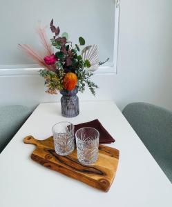 un vaso con fiori e due bicchieri su un tavolo di The Riverbank Suites, Central, New, Facilities a Collie Altre 23 foto