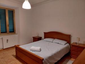 a bedroom with a bed with two night stands and a window at Appartamento Isabella in Pistoia