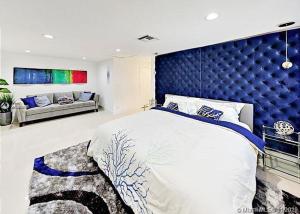 una camera da letto con un letto grande con testiera blu di The Chill Crib a Fort Lauderdale