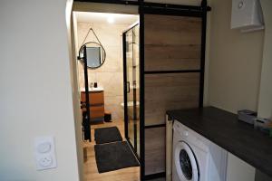 a bathroom with a sliding door with a washing machine at Cottage - La Petite Chaumière in Rouilly-Sacey