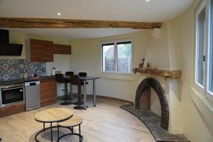 a kitchen with a fireplace and a table and chairs at Cottage - La Petite Chaumière in Rouilly-Sacey
