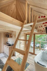una casa en el árbol con una escalera en medio de una habitación en Zagroda Krowiarki Chochołów, en Chochołów