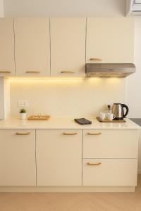 Una cocina con gabinetes blancos y un horno de estufa. en The Escape Kamala, en Kamala Beach