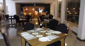 Un comedor con una mesa con platos y copas de vino. en Ma-Oya Retreat, en Andiramada