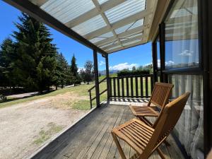 een paar stoelen op een afgeschermde veranda bij Mt Aspiring Holiday Park in Wanaka