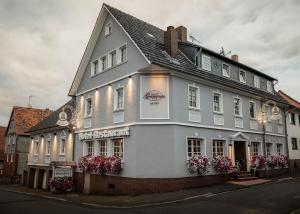 a white building with flowers in front of it at Hotel Germania in Stadtallendorf