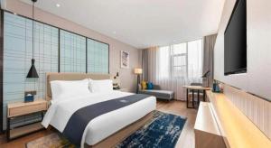 Un dormitorio con una cama grande y un televisor de pantalla plana. en Echarm Hotel Wuhan High-speed Rail Peace Park Metro Station, en Wuhan 207 fotos más