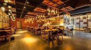 ein Restaurant mit Tischen, Stühlen und Kronleuchtern in der Unterkunft James Joyce Coffetel Kunming Railway Station Huancheng Nan Road Metro Station in Kunming