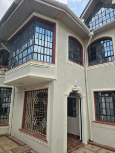 een huis met grote ramen en een poort bij Safaripark Gardens in Nairobi