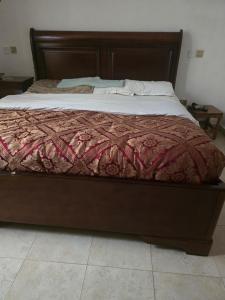 een bed in een slaapkamer met een houten bedframe bij Safaripark Gardens in Nairobi
