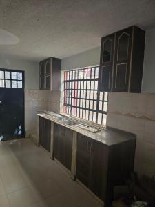 Een keuken die verbouwd wordt met houten kasten en ramen. bij Safaripark Gardens in Nairobi