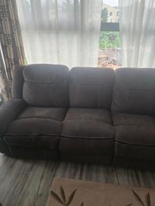 een bruine bank in een woonkamer met een raam bij Safaripark Gardens in Nairobi